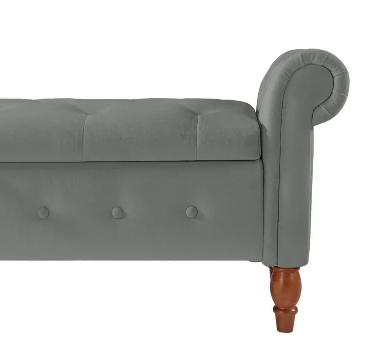 Light gray upholstered bench with tufted seat, rolled armrest, and wooden legs