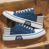 Blue and beige canvas sneakers with white soles and low-top casual streetwear style.