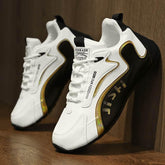 Modern white and black sneakers with gold accents, lace-up style, synthetic material, slim fit