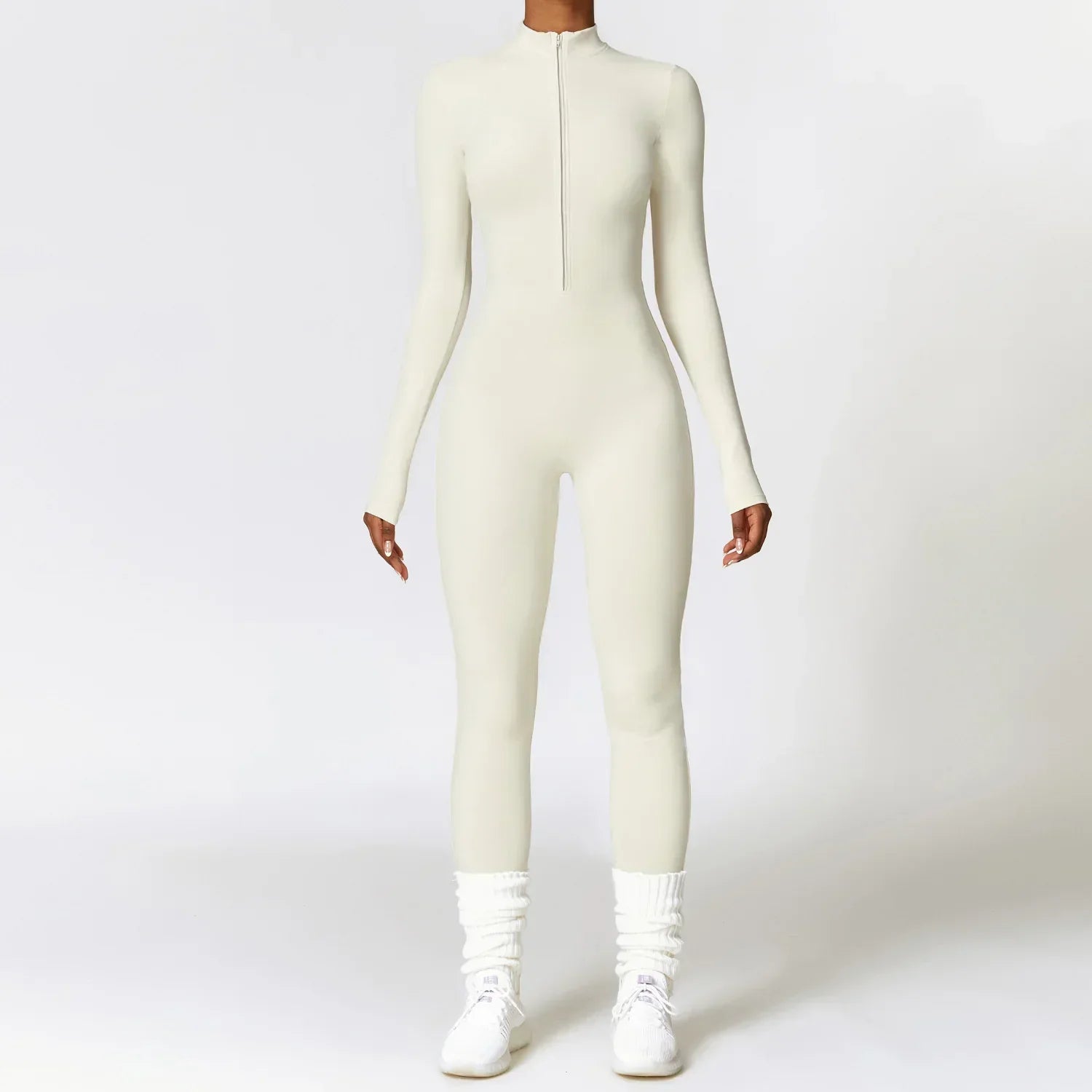 Woman wearing a fitted long sleeve white jumpsuit with front zipper, sporty streetwear style.