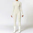 Woman wearing a fitted long sleeve white jumpsuit with front zipper, sporty streetwear style.