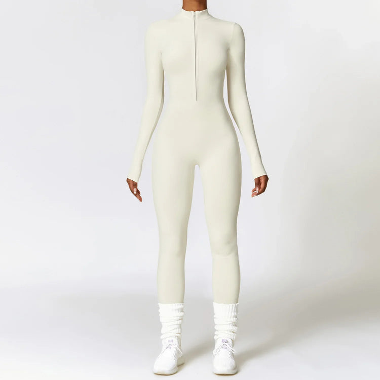 Woman wearing a fitted long sleeve white jumpsuit with front zipper, sporty streetwear style.