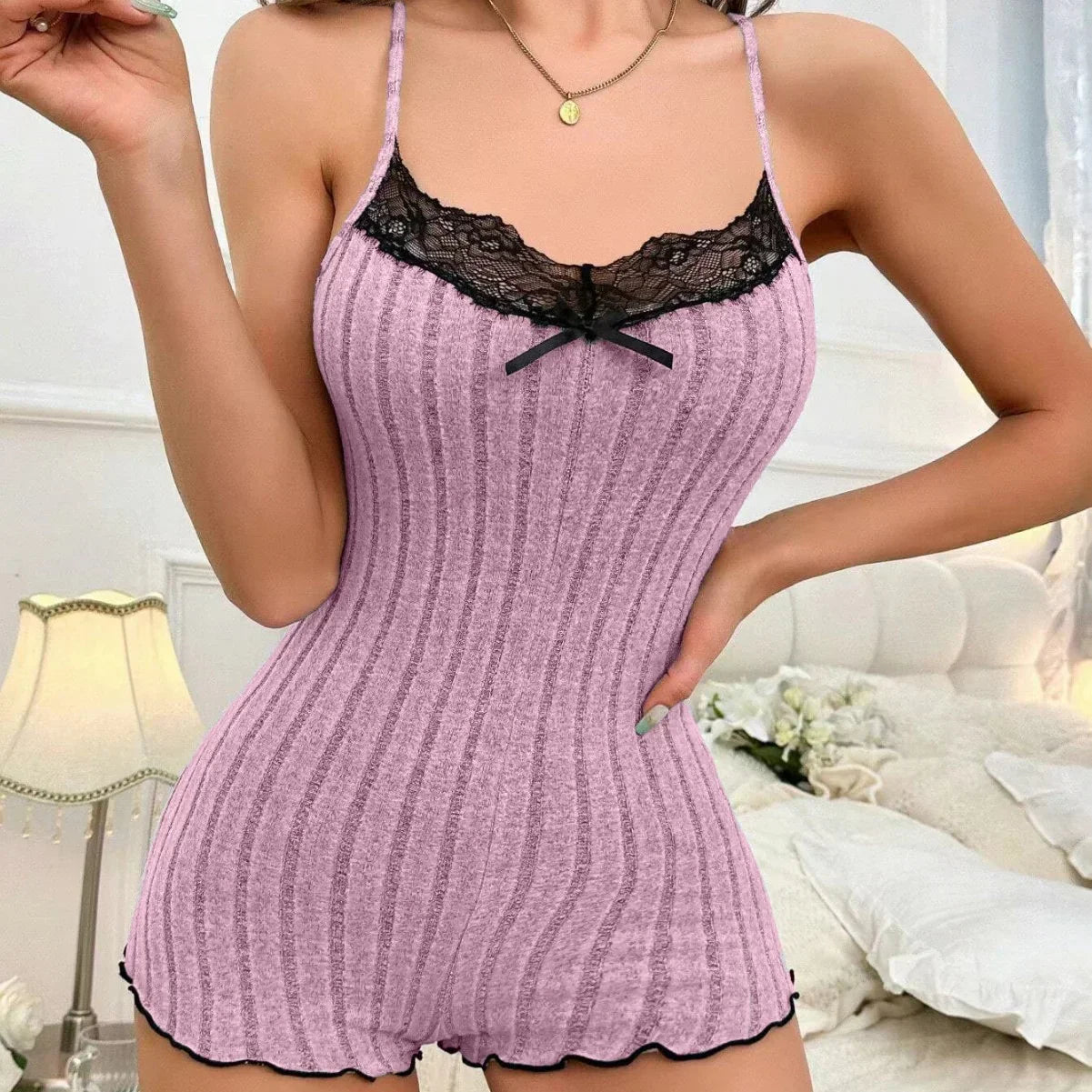Woman wearing ribbed lilac romper with lace trim, fitted sleeveless loungewear
