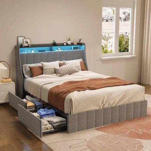 Modern grey upholstered bed with under-bed storage drawers and headboard shelf, neatly made with neutral bedding.
