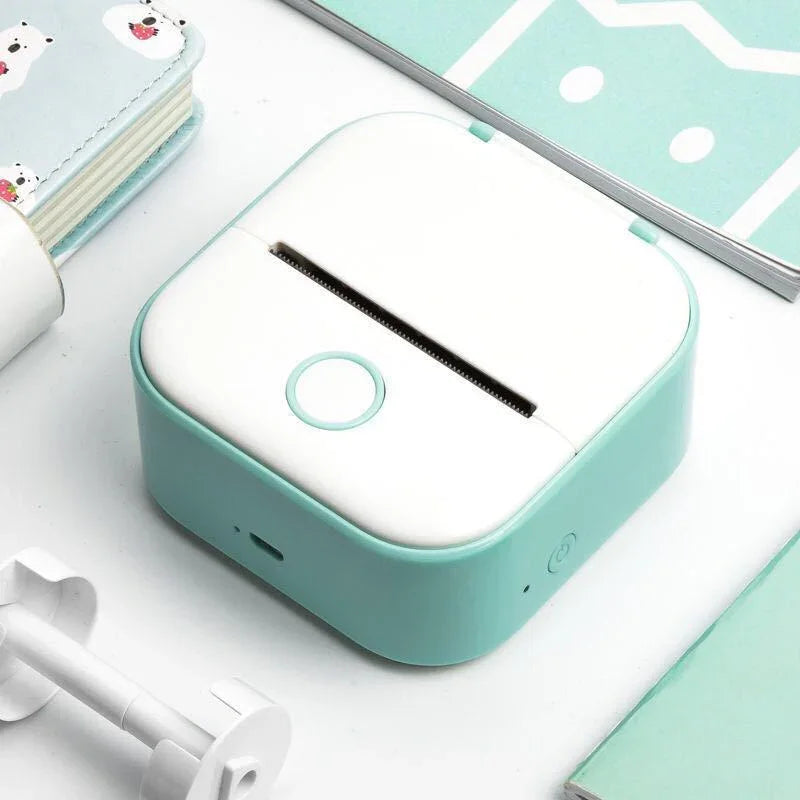 Compact mint green and white mini thermal printer on a desktop, modern minimalist design