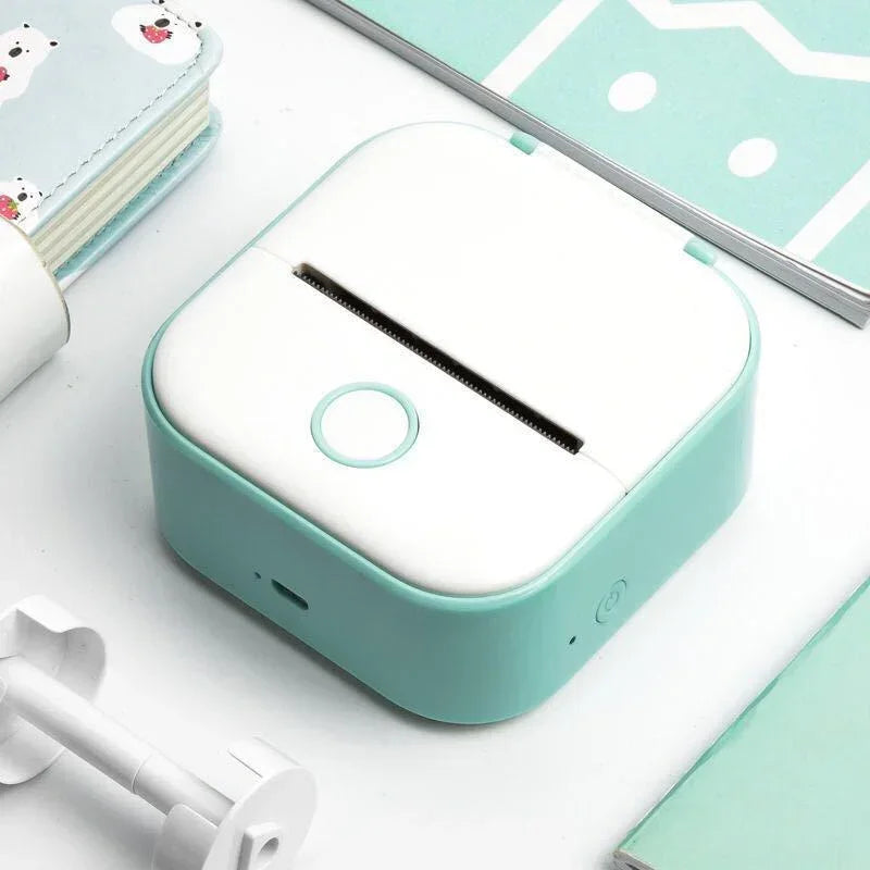 Compact mint green and white mini thermal printer on a desktop, modern minimalist design