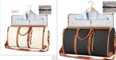 Two travel duffle bags, one cream and one black, with brown leather trim and handles, both holding a light blue dress shirt and laptop, displayed with matching toiletry bags.