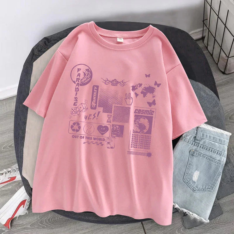 Pink oversized streetwear t-shirt with futuristic graphic print, laid flat next to denim shorts