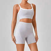 Woman wearing light grey seamless fitted crop top and high-waist biker shorts set