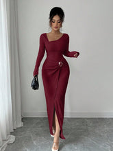 Woman wearing a fitted maroon long-sleeve ribbed dress with side slit and asymmetrical neckline
