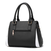 Black and white faux leather handbag with double handles, gold hardware, and front zipper pocket