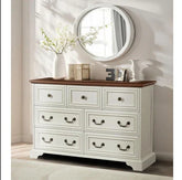 White wood dresser with dark wood top, ornate metal handles, and decorative home decor accents