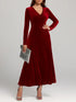 Woman wearing a long-sleeve red velvet maxi dress with a V-neck and fitted waist