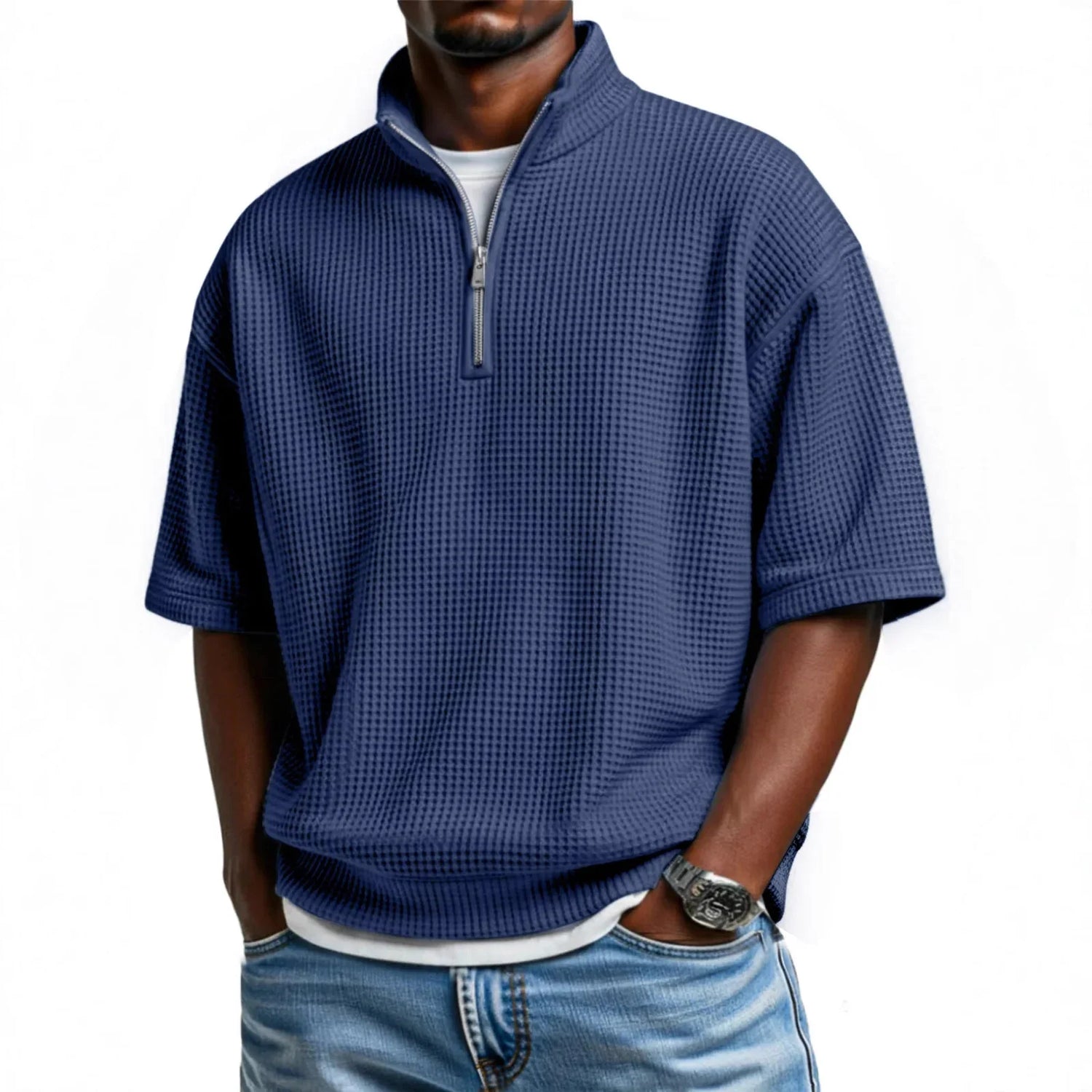 Man wearing a loose-fit blue waffle knit half-zip pullover with short sleeves and light denim jeans