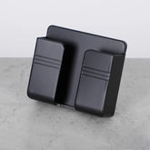 Matte black double-pocket wall organizer with a modern, minimalist design on a concrete surface
