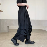 Wide-leg black streetwear pants with pleated details, relaxed fit, and elastic waist