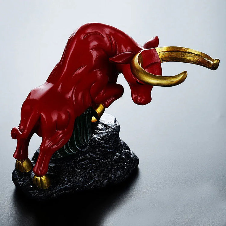 Red bull figurine with gold horns and hooves, modern resin sculpture on black base