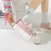 Light pink canvas platform sneakers with chunky white soles, paired with white socks.
