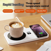 White ceramic cup with latte art on a mug warmer and smartphone on wireless charging pad