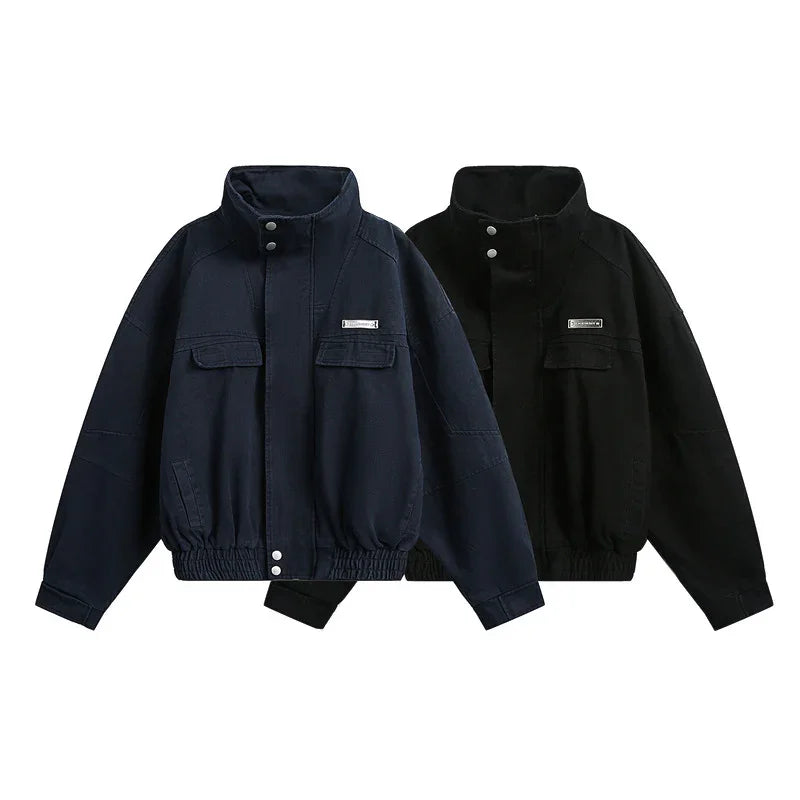 Two oversized zip-up jackets, one navy and one black, with chest pockets and elastic hems.