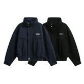 Two oversized zip-up jackets, one navy and one black, with chest pockets and elastic hems.