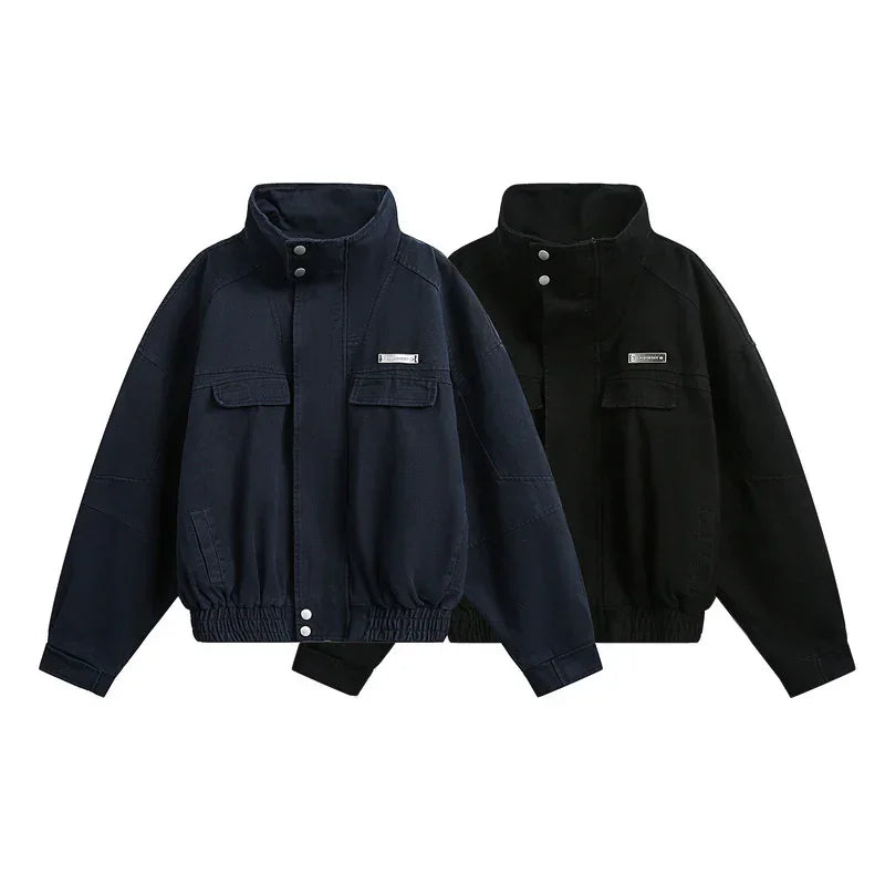 Two oversized zip-up jackets, one navy and one black, with chest pockets and elastic hems.