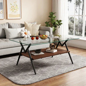 Modern living room with light grey sofa, geometric pillows, and a glass coffee table on a patterned rug