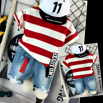 Red and white striped short sleeve t-shirt with relaxed fit, paired with ripped denim shorts and a white cap featuring bold numbers, displayed in a modern setting.
