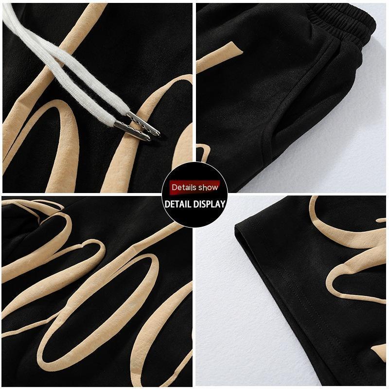 Black sweatpants with beige graphic print, elastic waistband, metal-tipped drawstrings, relaxed fit
