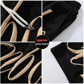Black sweatpants with beige graphic print, elastic waistband, metal-tipped drawstrings, relaxed fit