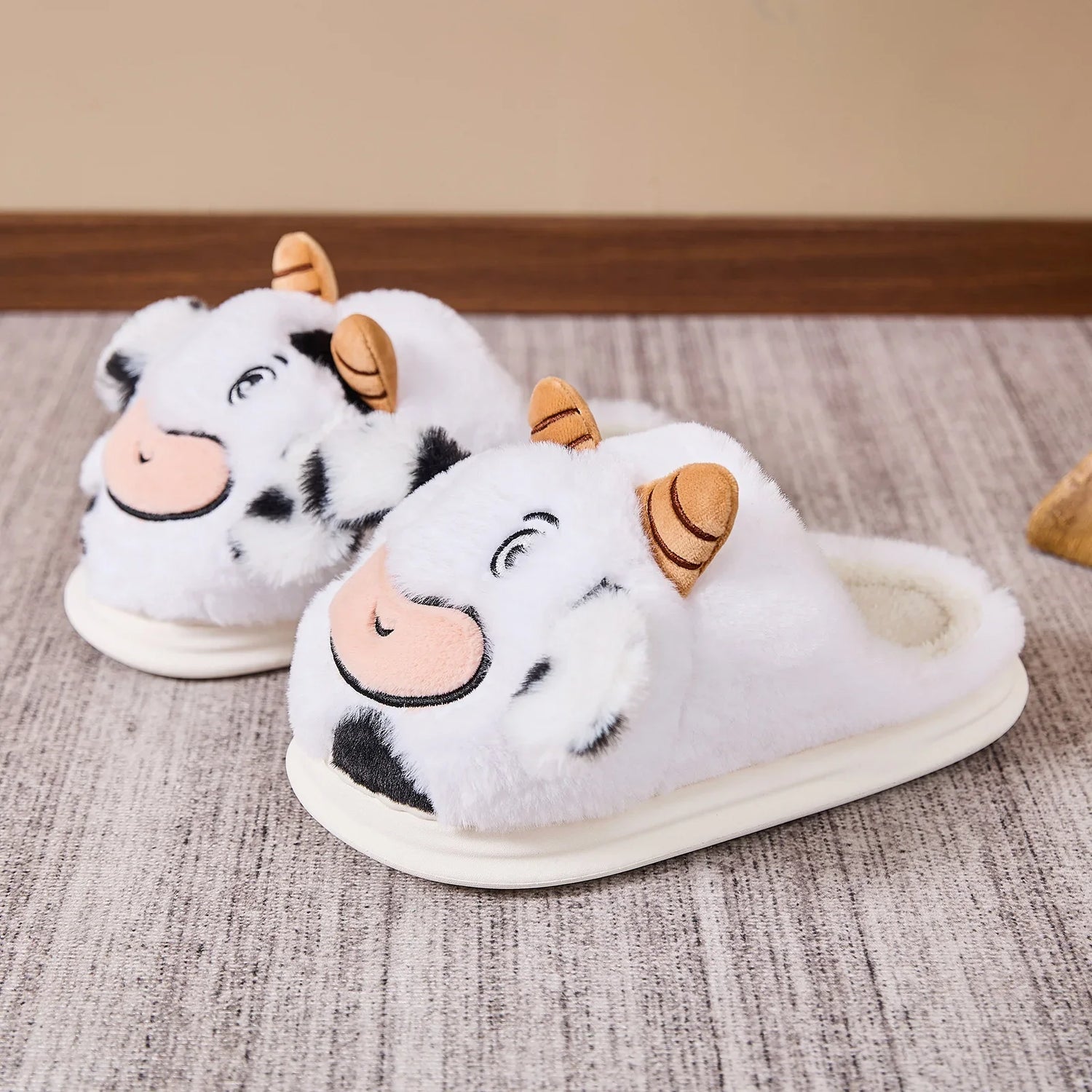 Plush white cow slippers with black spots, cartoon face design, and soft slip-on fit