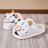 Plush white cow slippers with black spots, cartoon face design, and soft slip-on fit