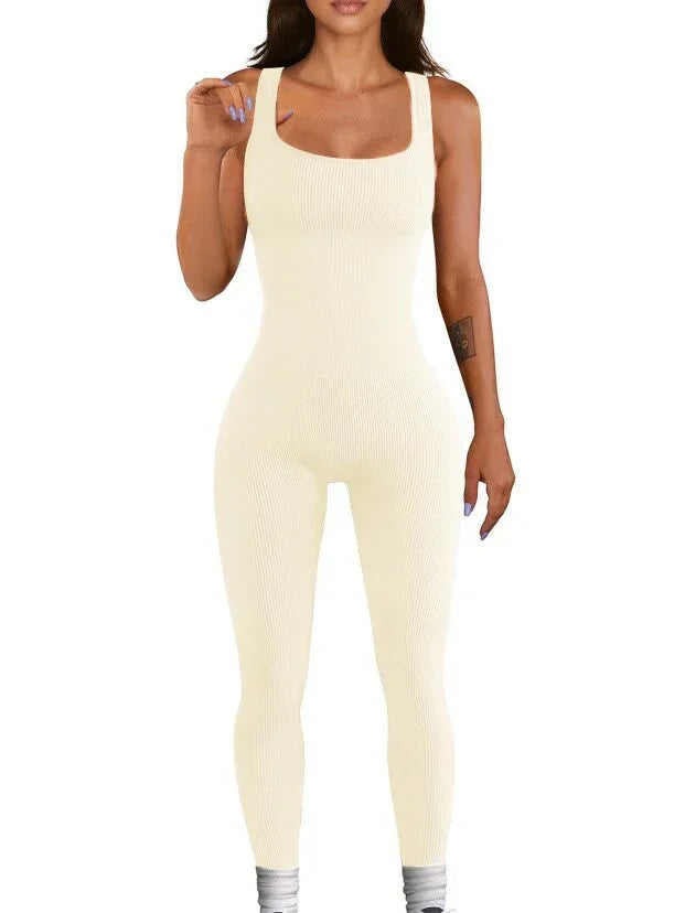 Woman wearing a fitted beige ribbed sleeveless jumpsuit, full length, with a square neckline.