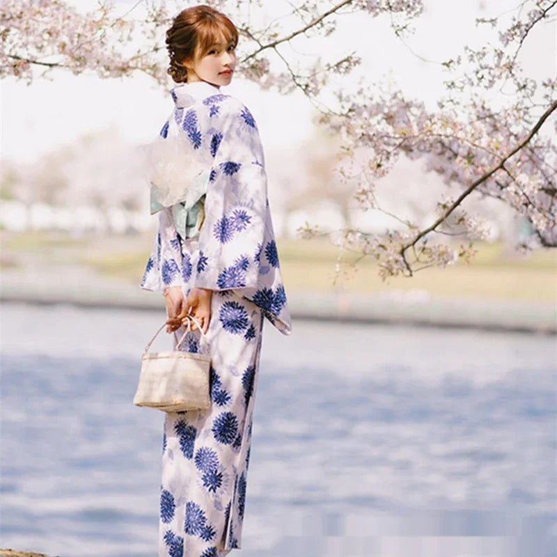 Woman wearing floral patterned kimono, light fabric, relaxed fit, standing by water
