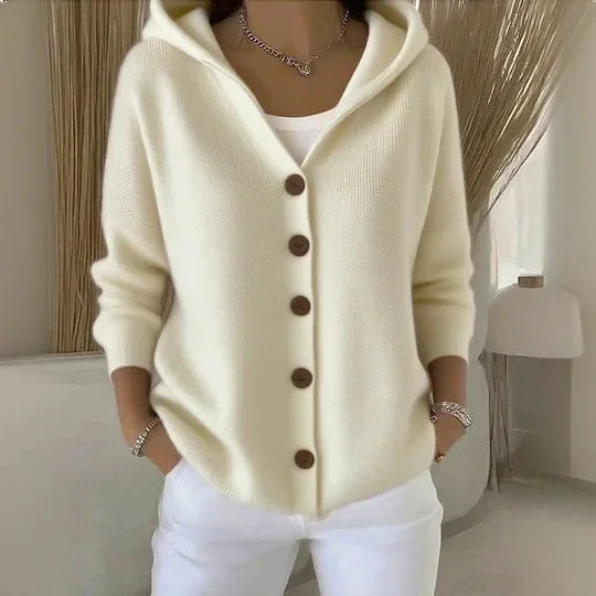 Cream knit hooded cardigan with brown buttons, relaxed fit, paired with white pants