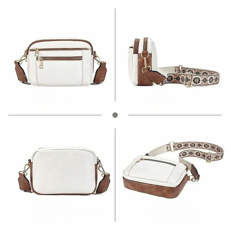White and brown crossbody bag with gold zippers, patterned adjustable strap, and rectangular shape.