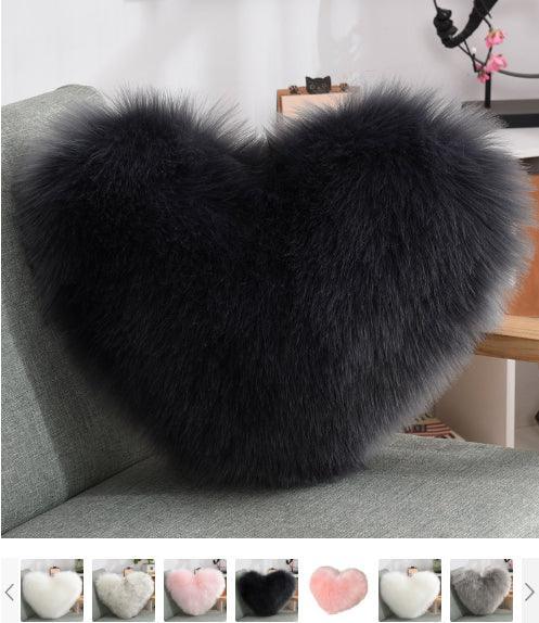 Black heart-shaped faux fur pillow on a sofa, plush texture, cozy home decor accessory