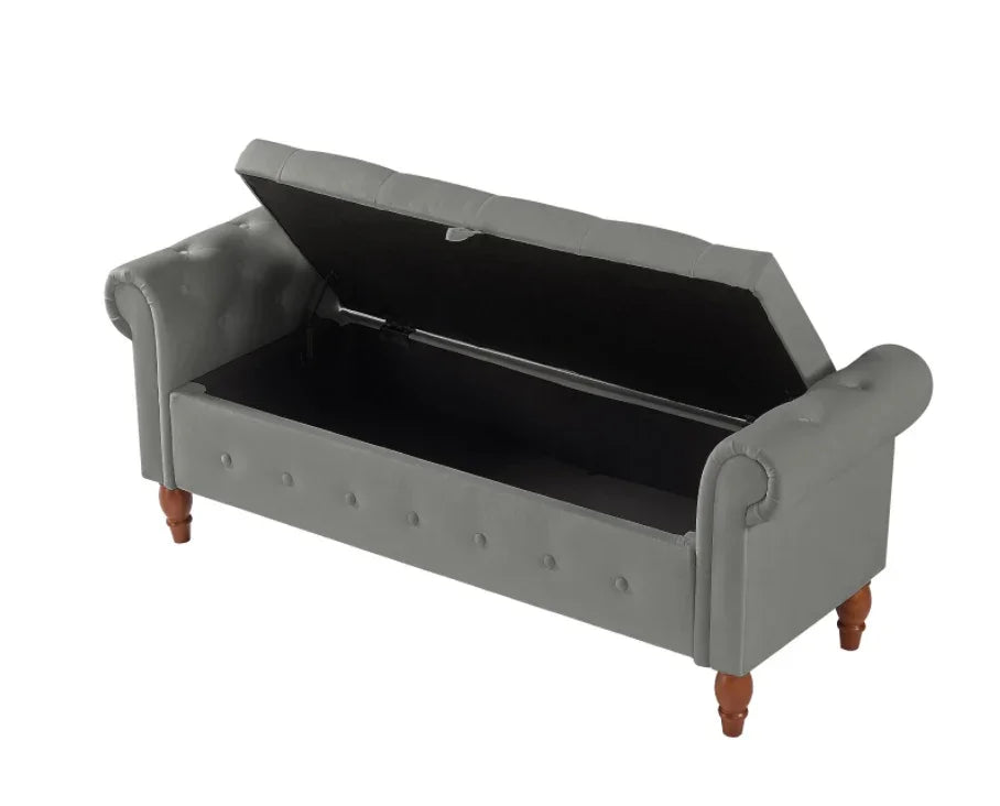 Gray upholstered storage bench with wooden legs and tufted button details, open lid