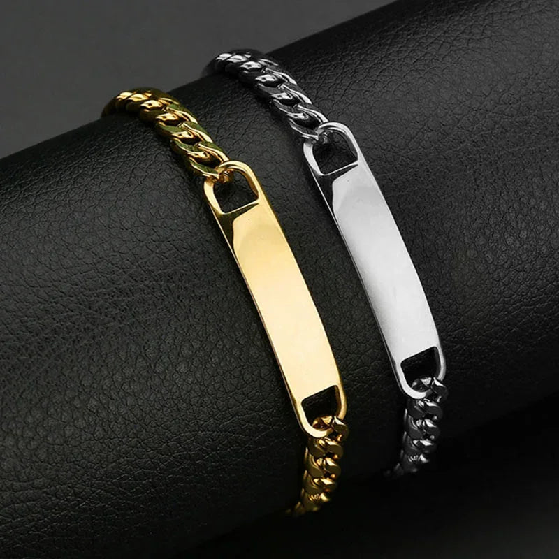 Gold and silver curb chain bracelets with polished metal plates on black leather background