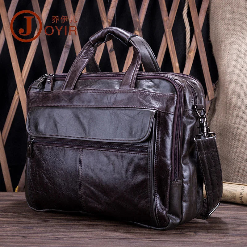 Dark brown leather messenger bag with front zipper pocket and adjustable shoulder strap on wood table