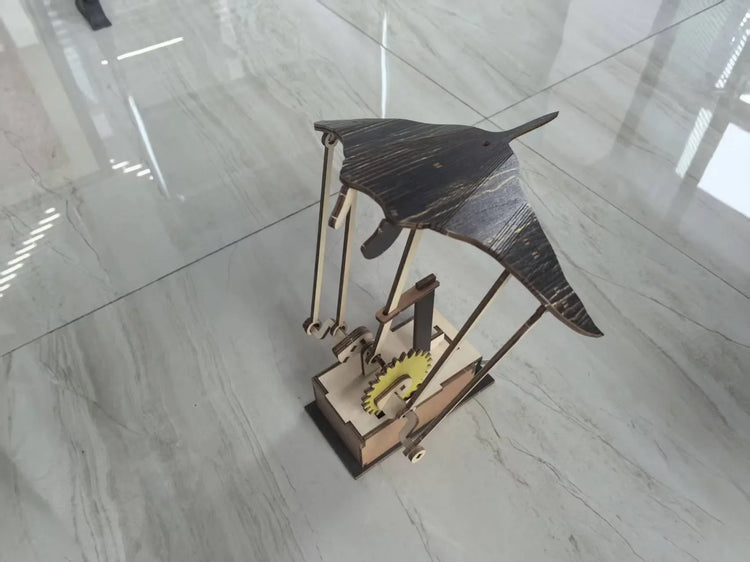 Wooden mechanical model of a manta ray with gear mechanism on light marble floor
