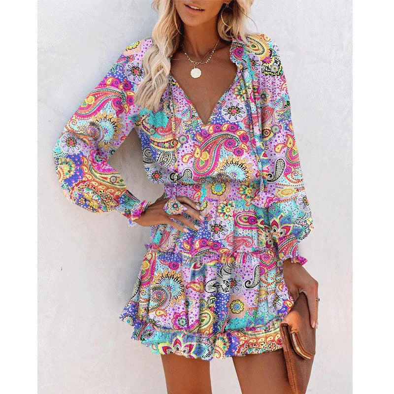 Woman wearing a colorful paisley print boho dress with long sleeves and ruffled mini skirt
