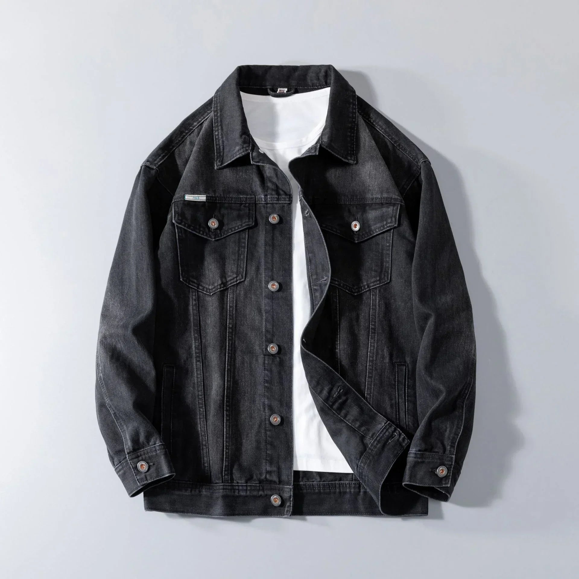 Black denim jacket with button closure and relaxed fit over a white t-shirt