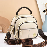 Cream faux leather crossbody bag with gold zippers, brown adjustable strap, structured fit