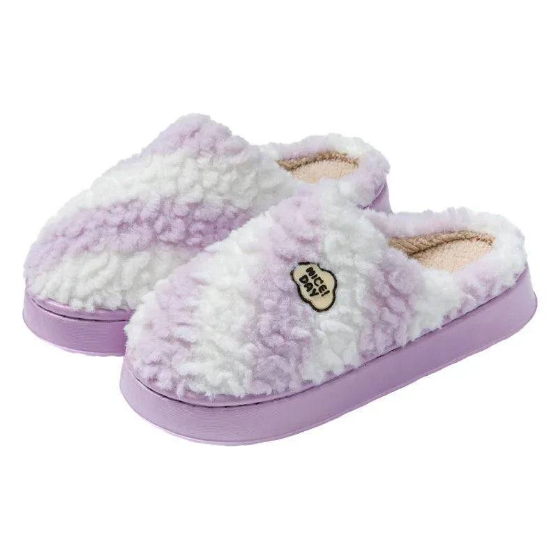 Plush lavender and white slip-on slippers with fuzzy texture and cozy fit, featuring soft soles.
