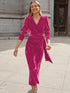 Woman in a vibrant pink velvet wrap dress with long sleeves and a fitted waist, street style