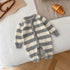 Fuzzy gray and white striped baby romper with long sleeves and wooden buttons, laid flat