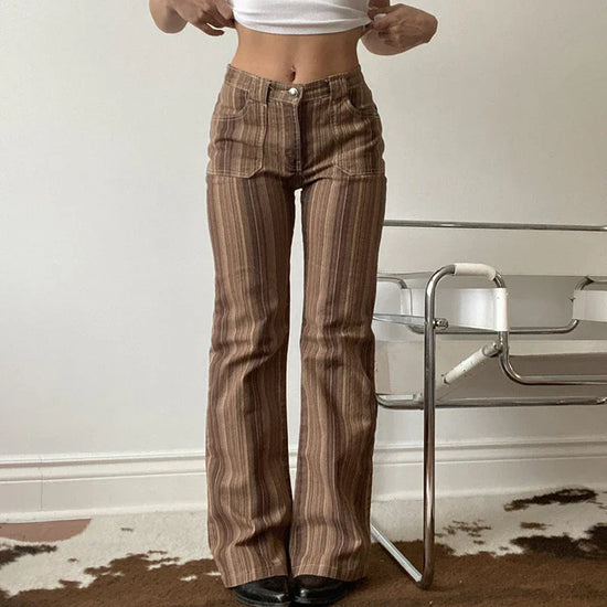Woman wearing high-waisted brown striped flared pants with a close fit, standing indoors.