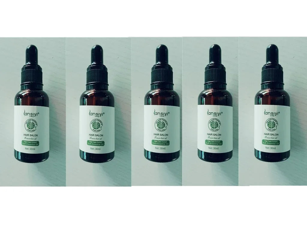 Five brown dropper bottles with white labels, containing essential hair oil, displayed in a row.