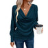 Woman wearing a teal draped cowl neck long sleeve top and fitted blue jeans